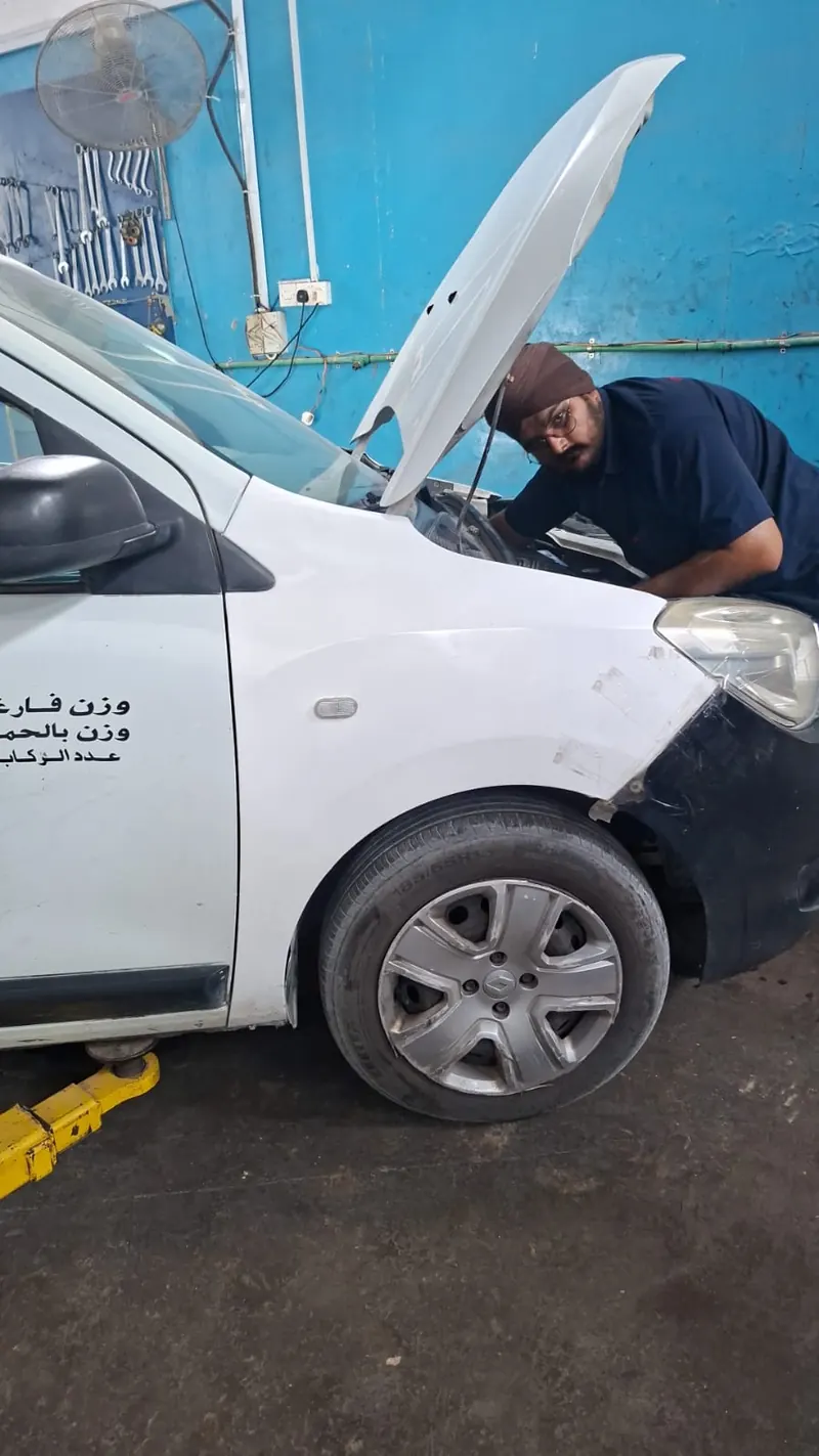 Technician inspecting under the bonnet of a hatchback
