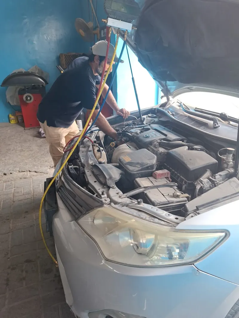 Technician servicing a car AC system